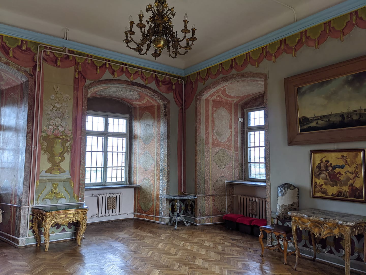 A restored interior room hung with large paintings